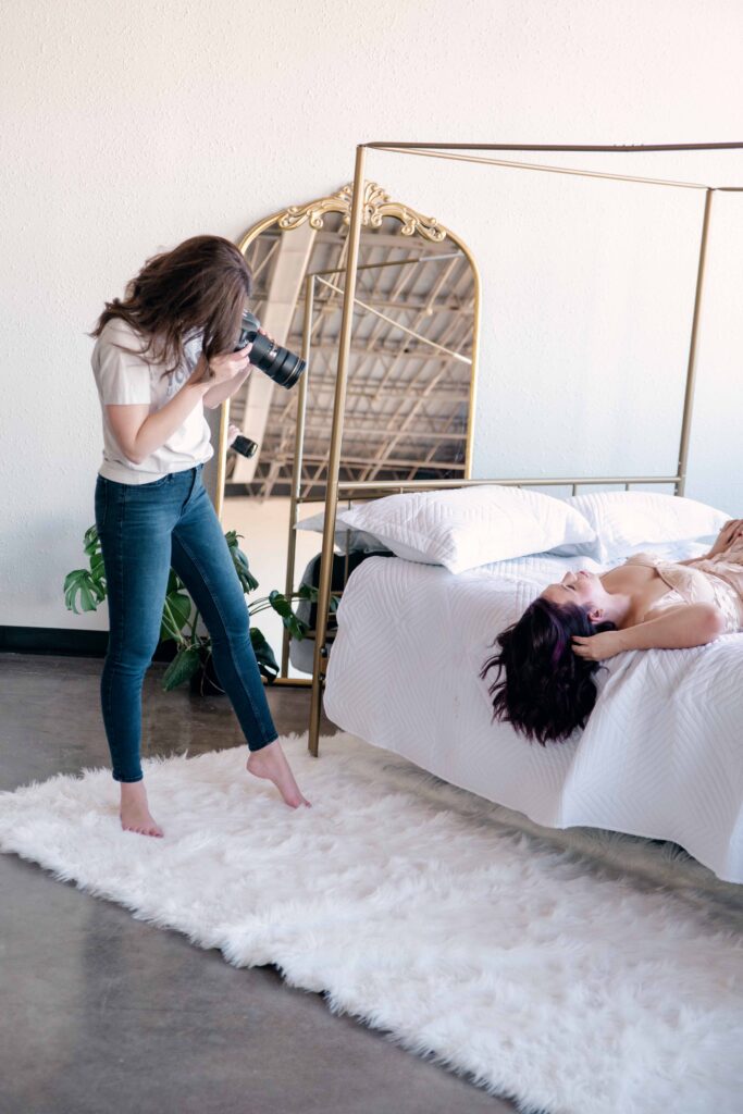 kalee isenhour photographing woman on bed during boudoir session in Oklahoma