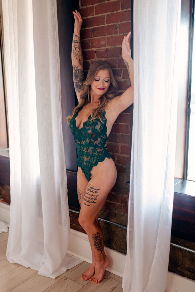 woman wearing lace bodysuit during boudoir session