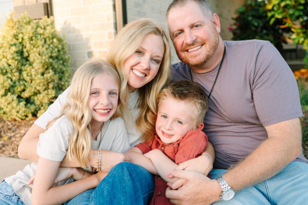 Lifestyle family photography in Oklahoma City featuring a family playing together in their front yard